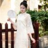 Áo dài cách Tân ren thêu hoa tong kem nút cam